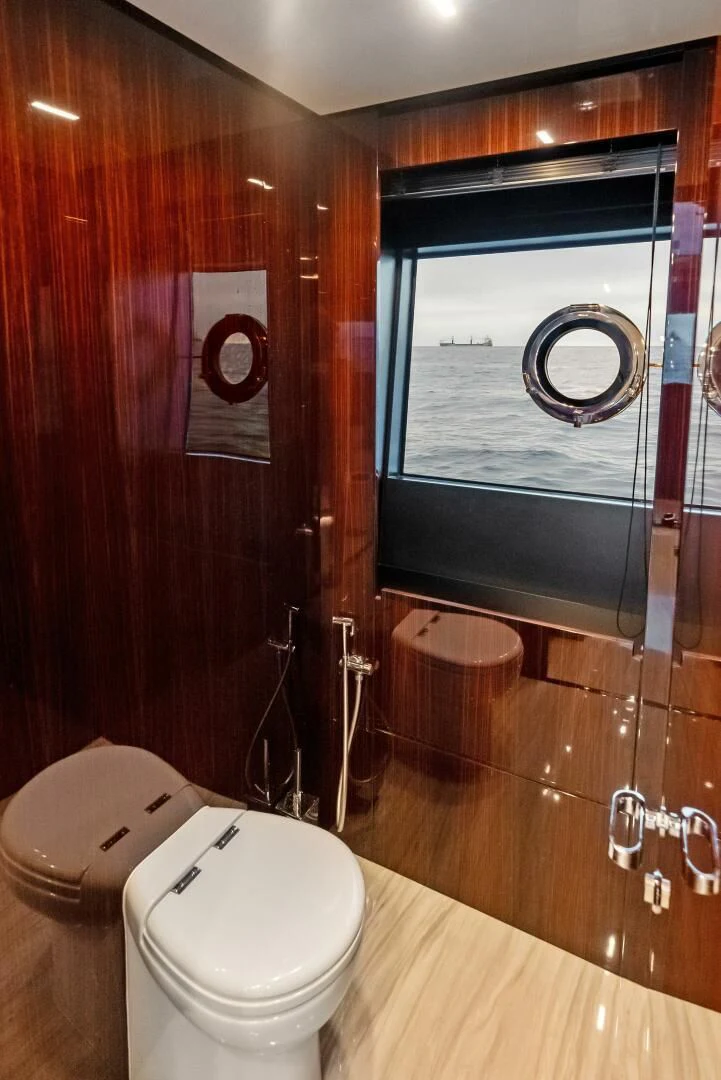 a bathroom with a toilet and a mirror aboard OUR TRADE Yacht for Sale