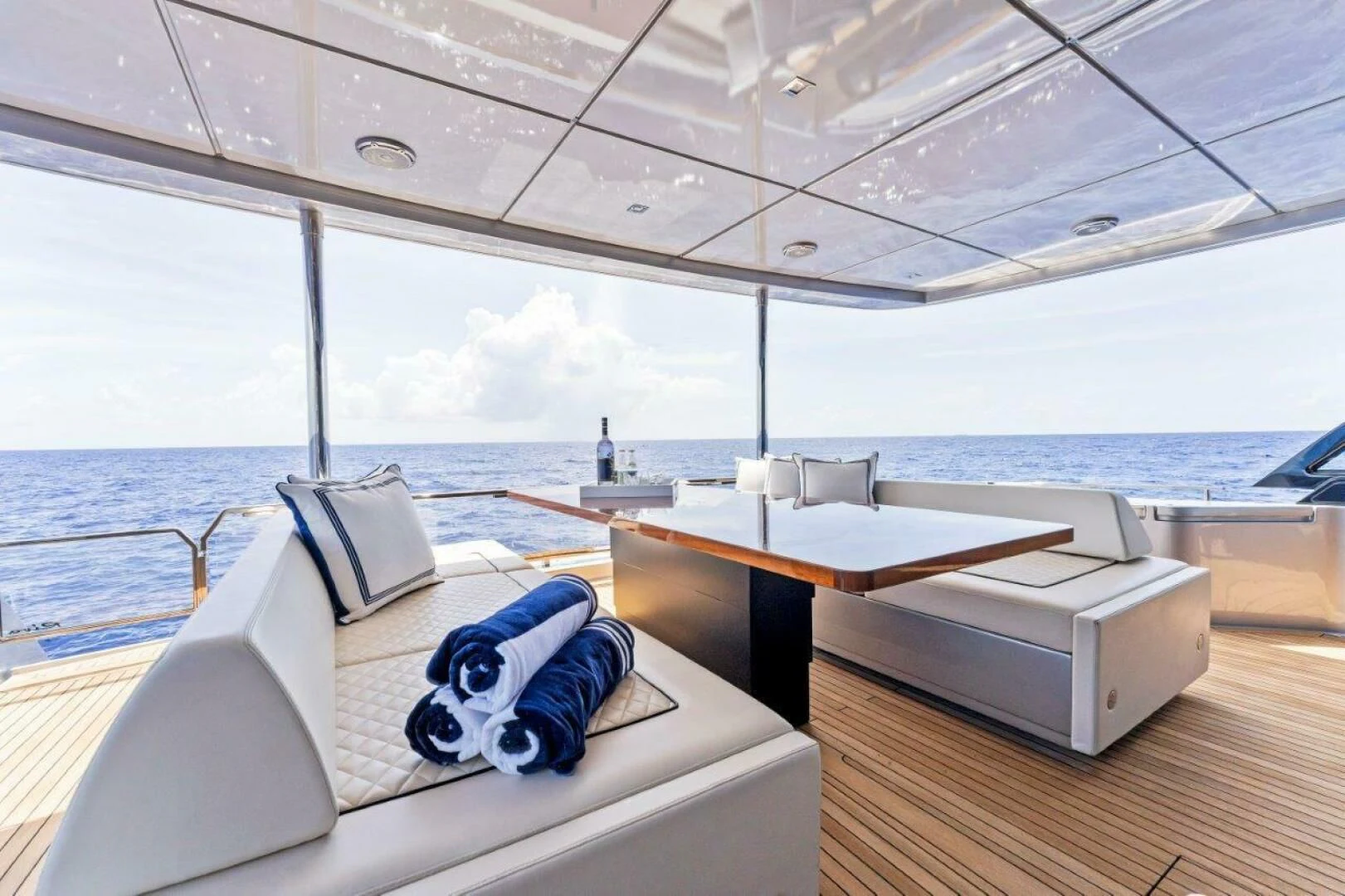 a room with a bed and a table with a view of the ocean aboard OUR TRADE Yacht for Sale