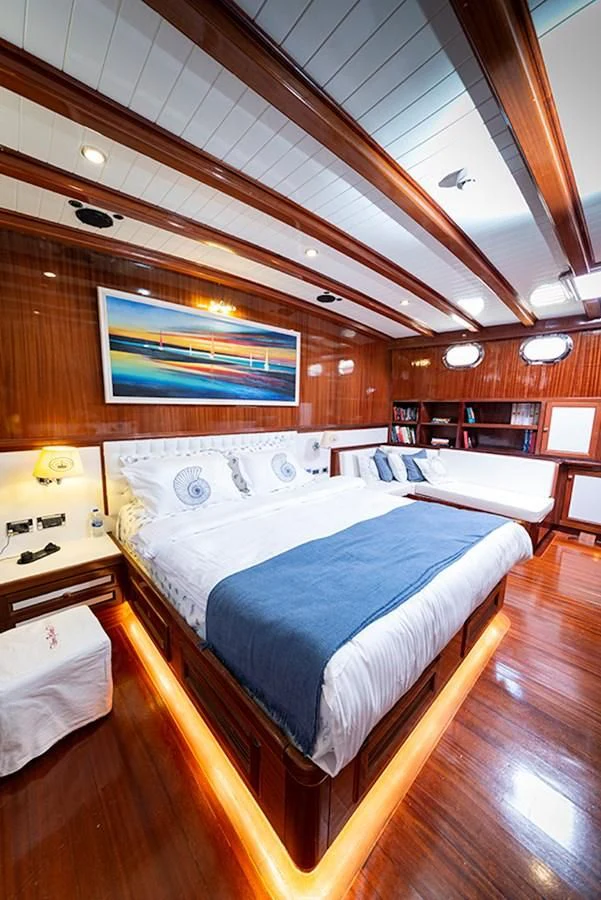 a room with a bed and a table aboard QUEEN OF DATCA Yacht for Charter