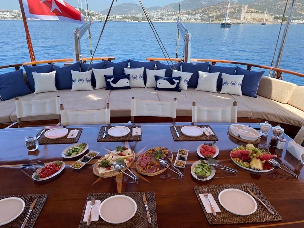 a table with plates and food on it aboard QUEEN OF DATCA Yacht for Charter