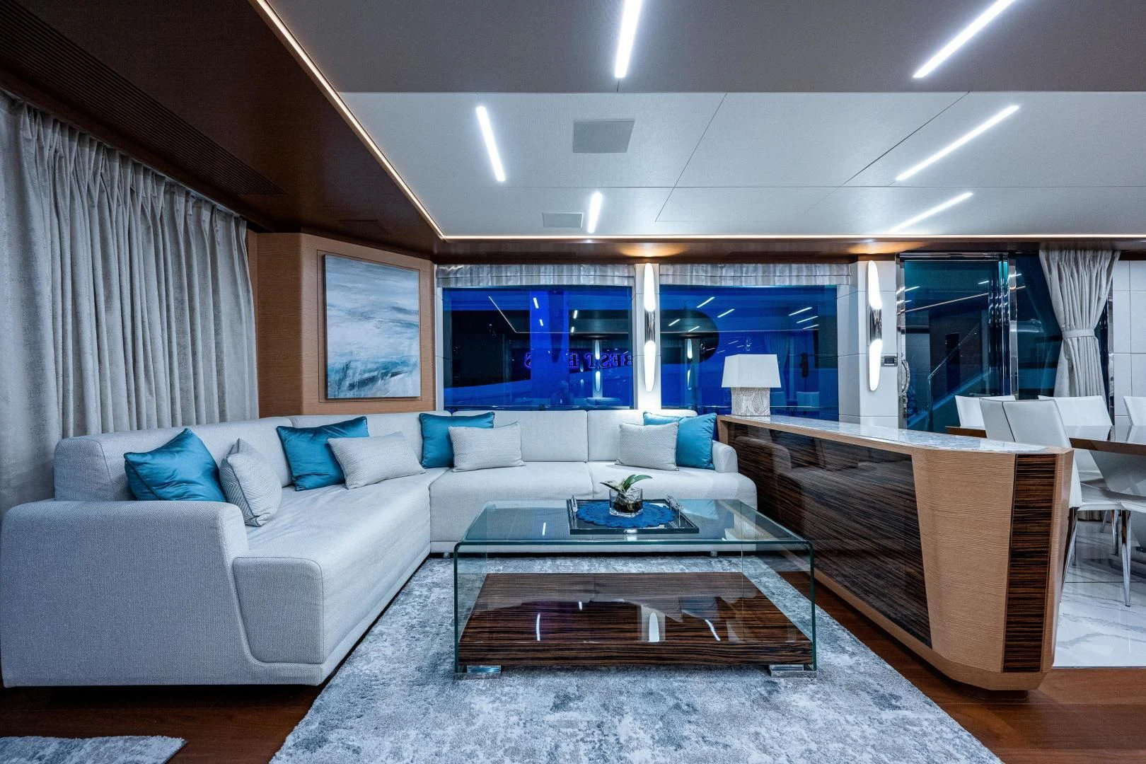 a living room with a large glass coffee table aboard SEASUITE Yacht for Charter