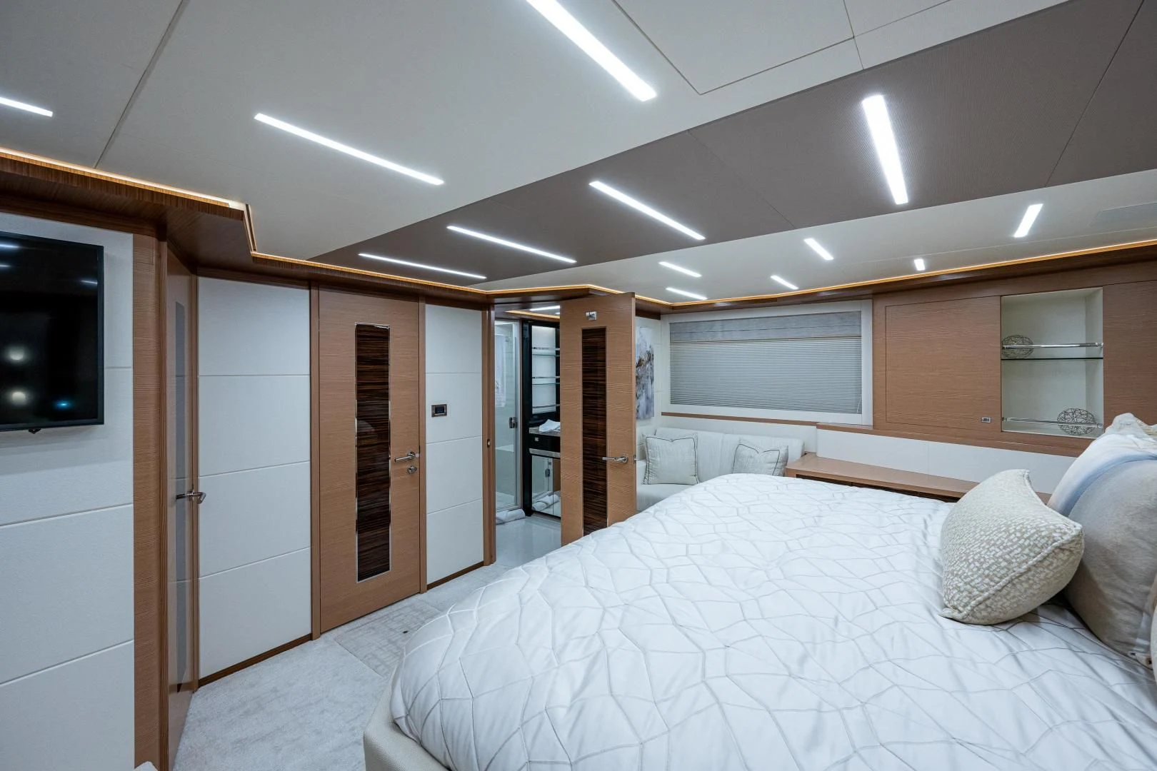 a room with a bed and a television aboard SEASUITE Yacht for Charter