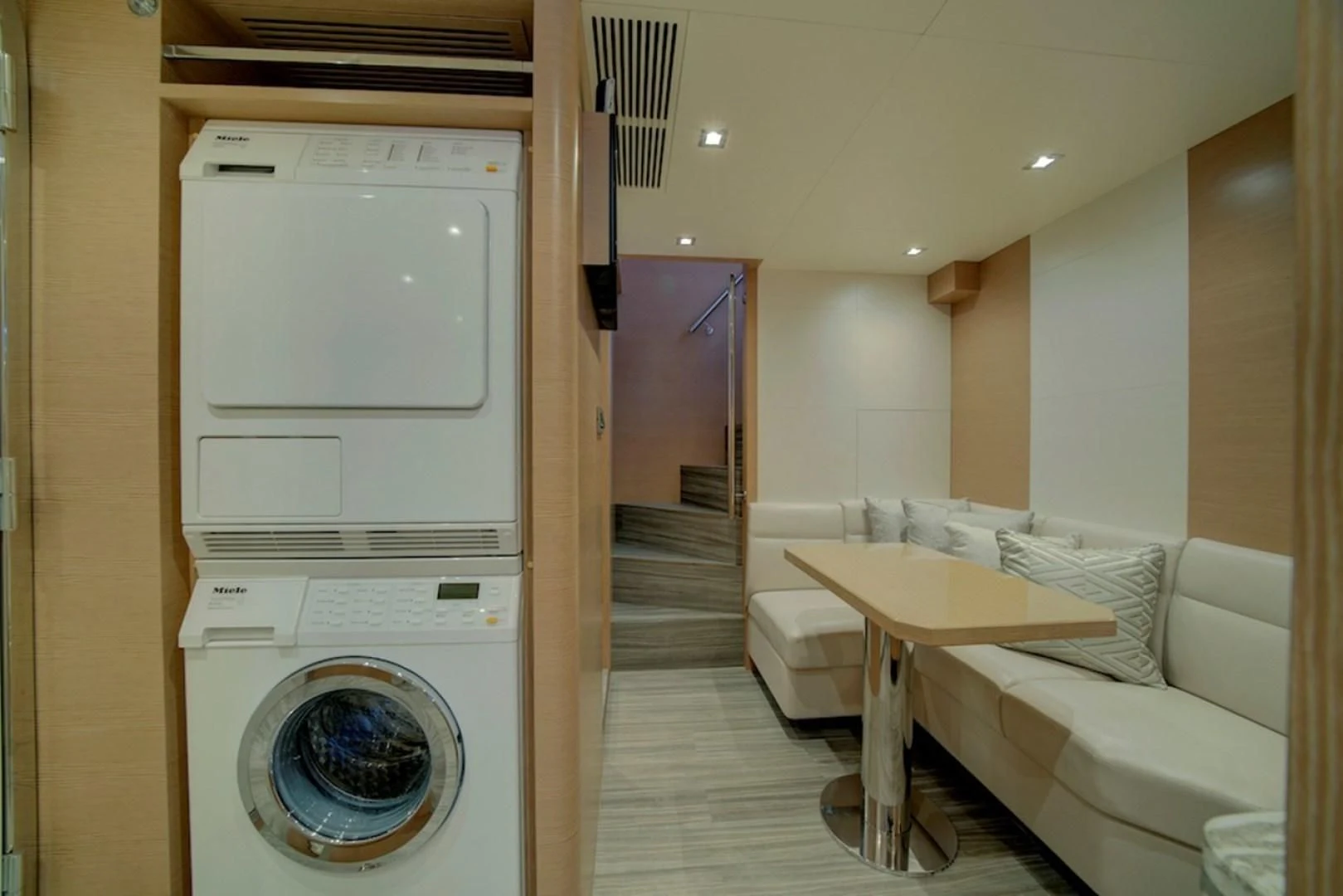 a room with a washing machine and a couch aboard SEASUITE Yacht for Charter