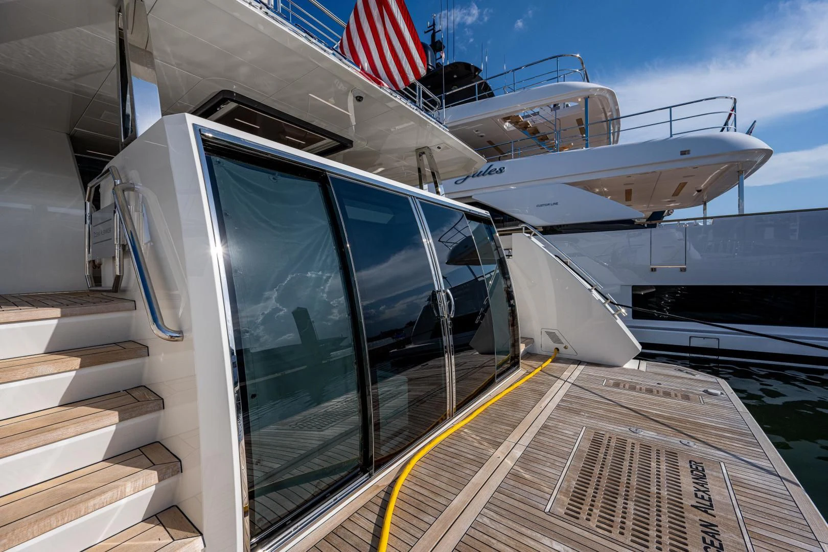 a large white boat with a flag on the deck aboard SEASUITE Yacht for Charter