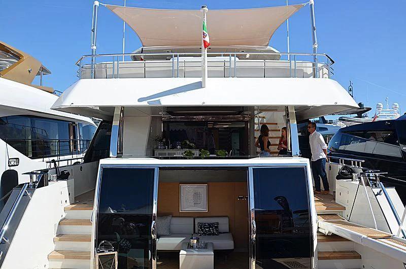 a boat with a deck and a couple of people standing on the deck aboard SEASUITE Yacht for Charter
