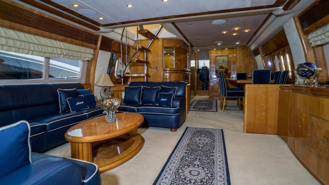 a living room with a blue couch and a wood coffee table aboard AVICCI Yacht for Sale