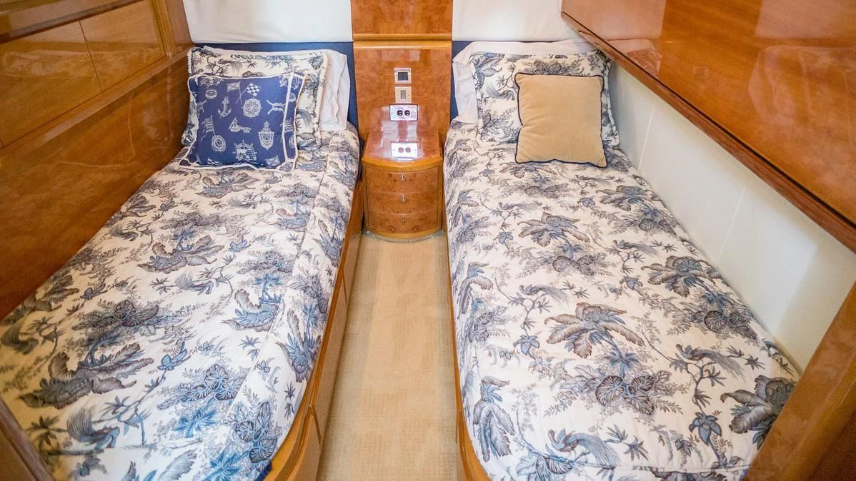 a bed with a blue and white pillow and a wooden headboard aboard AVICCI Yacht for Sale