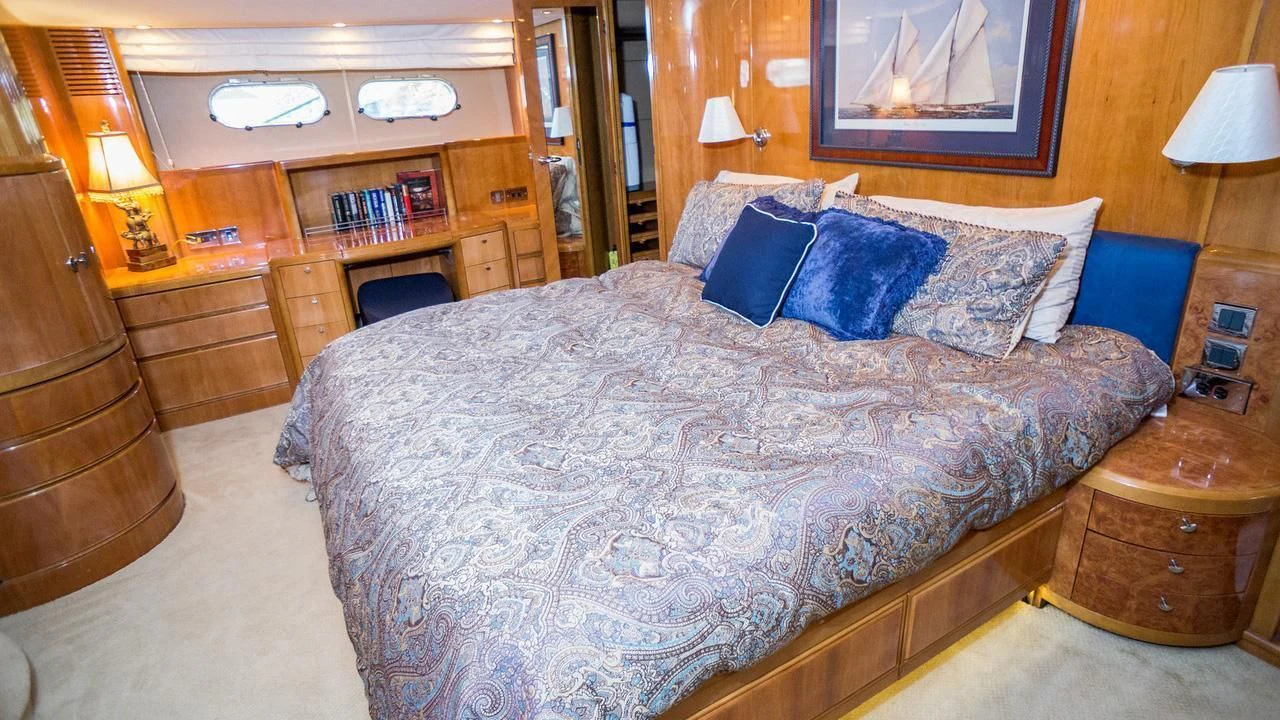 a bed with blue pillows aboard AVICCI Yacht for Sale