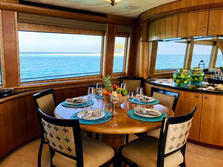 a dining table with plates and glasses aboard EQUINOX X Yacht for Sale