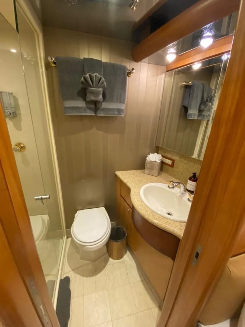 a bathroom with a sink toilet and towels aboard EQUINOX X Yacht for Sale