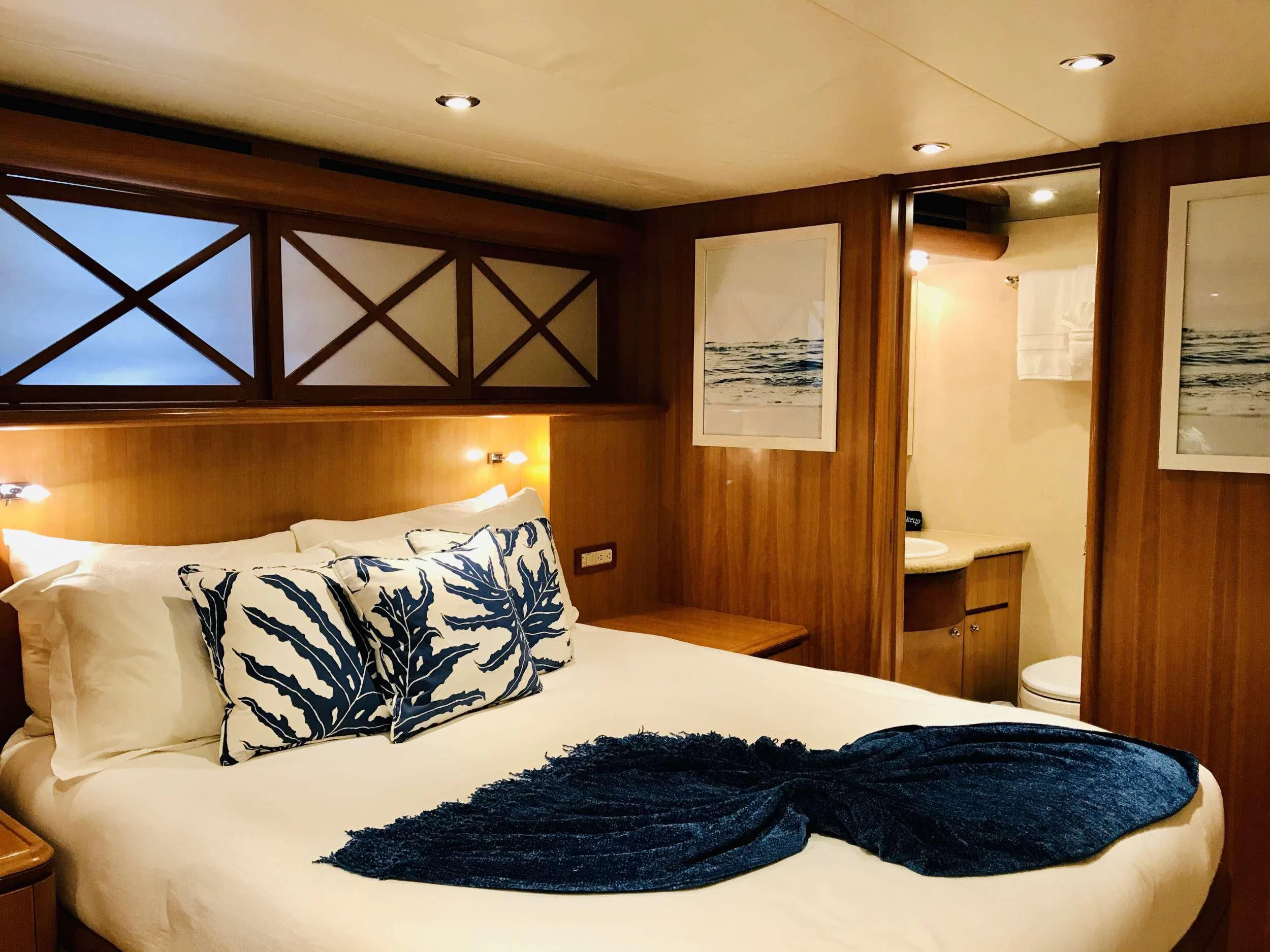 a bedroom with a bed and a mirror aboard EQUINOX X Yacht for Sale