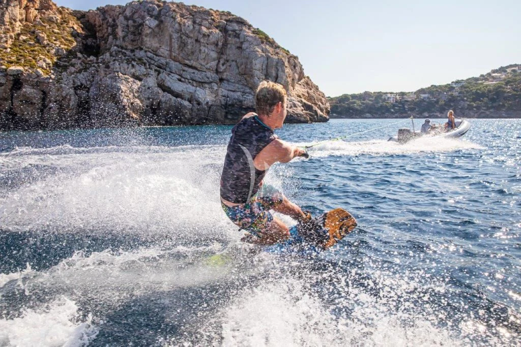 a man riding a surfboard in the water aboard ARAGON Yacht for Sale