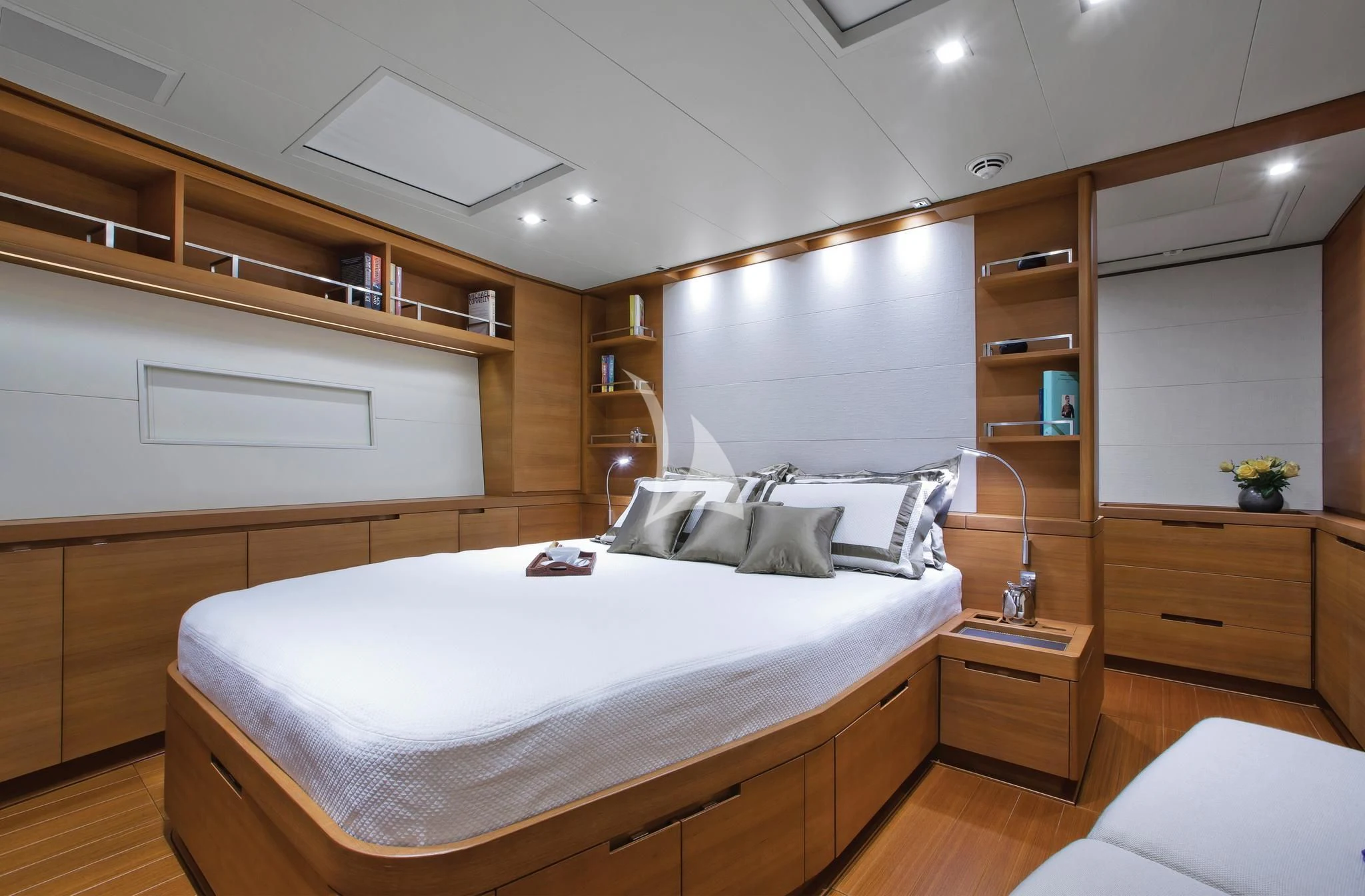 a room with a bed and a shelf with books on it aboard ARAGON Yacht for Sale