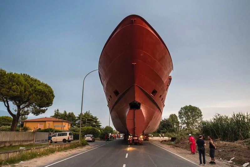 a large red cylindrical object on a road with people standing around aboard ATTILA Yacht for Sale