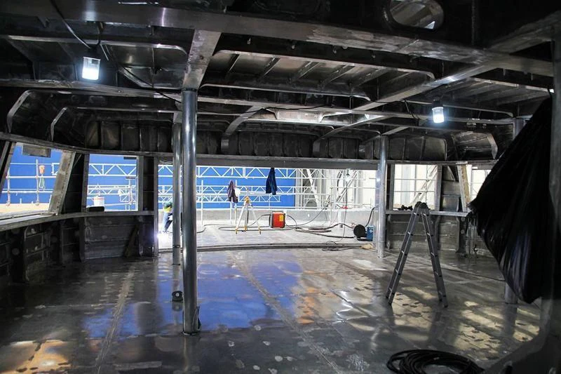 a large room with a large white and blue floor and a few people in it aboard ATTILA Yacht for Sale