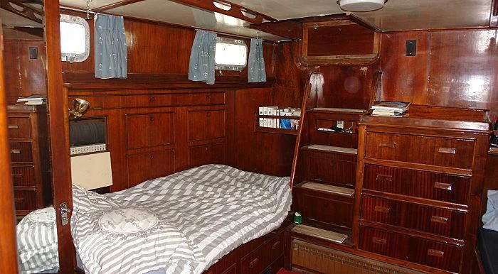 a room with a bed and a bookcase aboard WHITE EAGLE Yacht for Sale