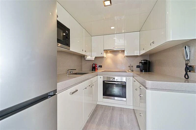 a kitchen with white cabinets aboard ADAMO Yacht for Sale