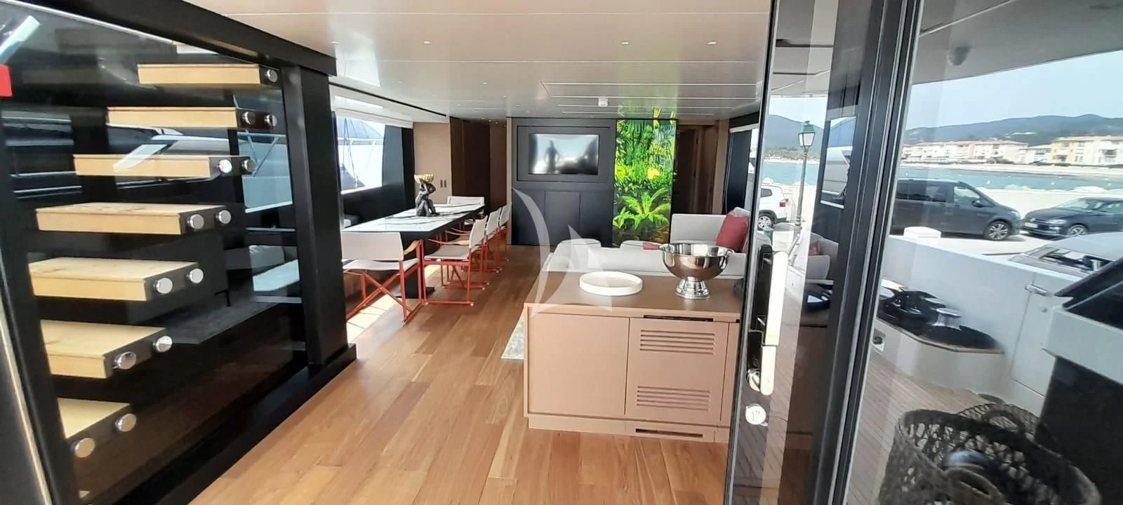 a room with a wood floor and a large window with a view of a city aboard SSL Yacht for Sale