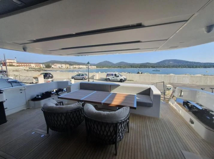 a deck with chairs and a table on it aboard SSL Yacht for Sale