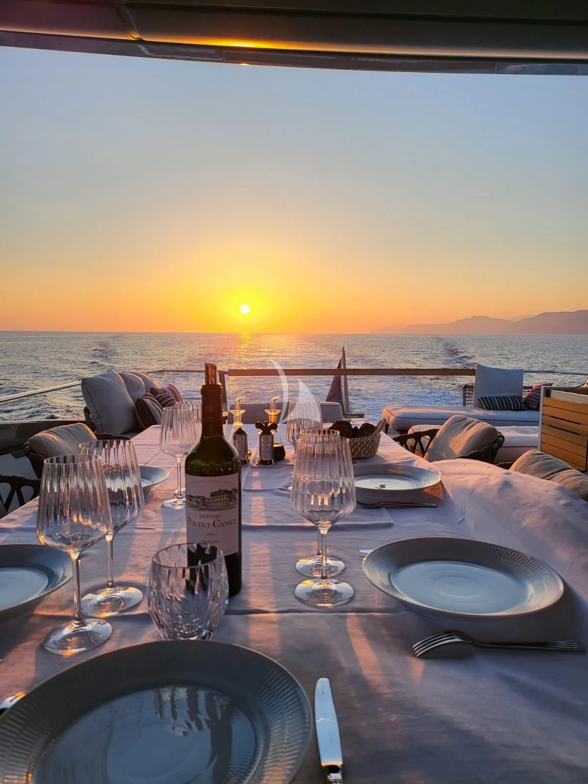 a table with wine bottles and glasses on it aboard SSL Yacht for Sale