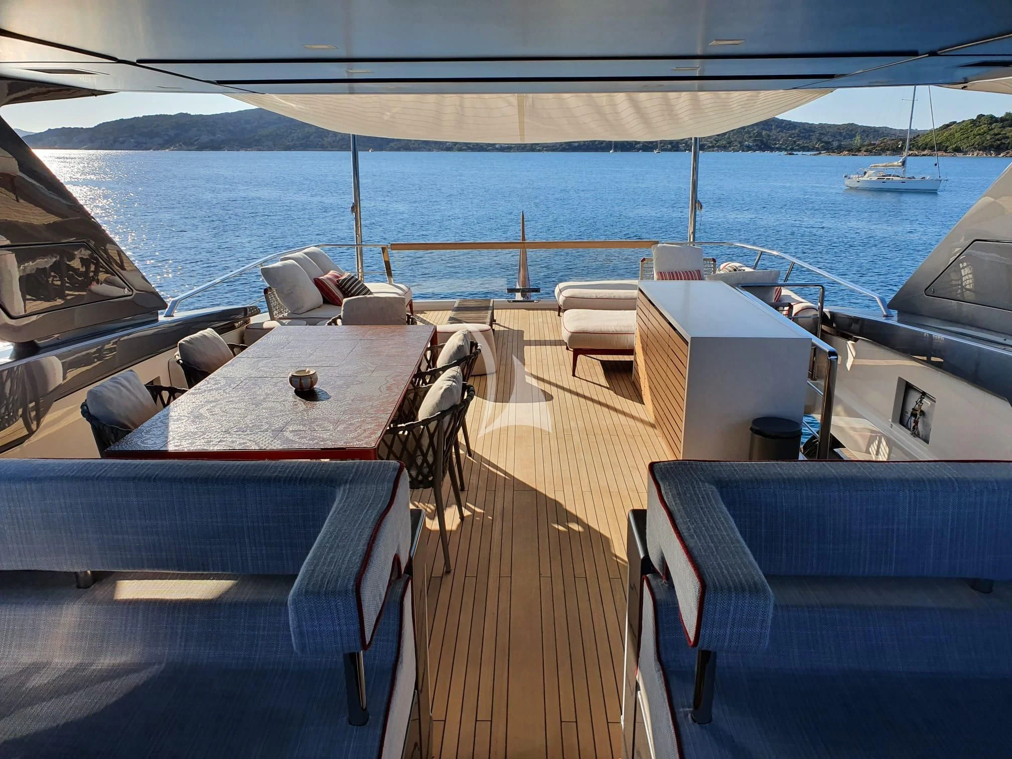a deck with a table and chairs on it aboard SSL Yacht for Sale