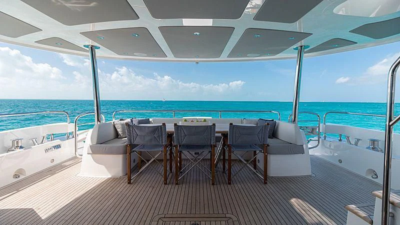 a deck with chairs and tables on it aboard SYNERGY Yacht for Sale