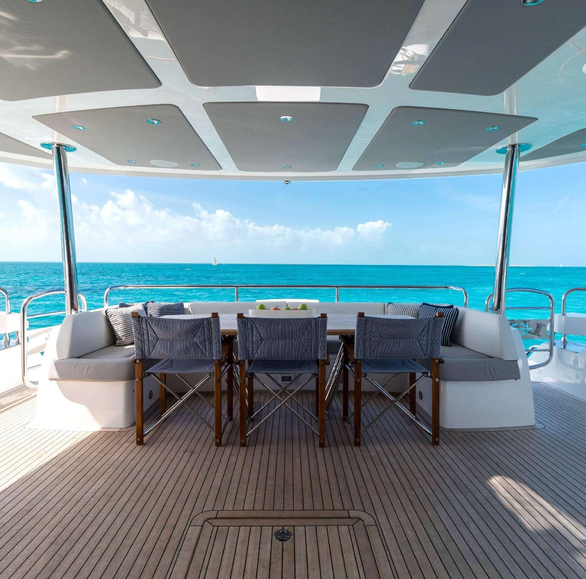 a table and chairs on a deck overlooking the ocean aboard SYNERGY Yacht for Sale