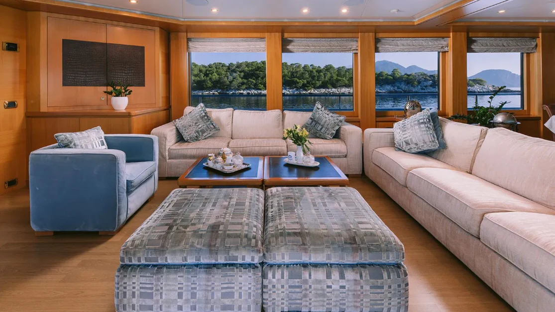 a living room with a couch and a table aboard OASIS Yacht for Sale