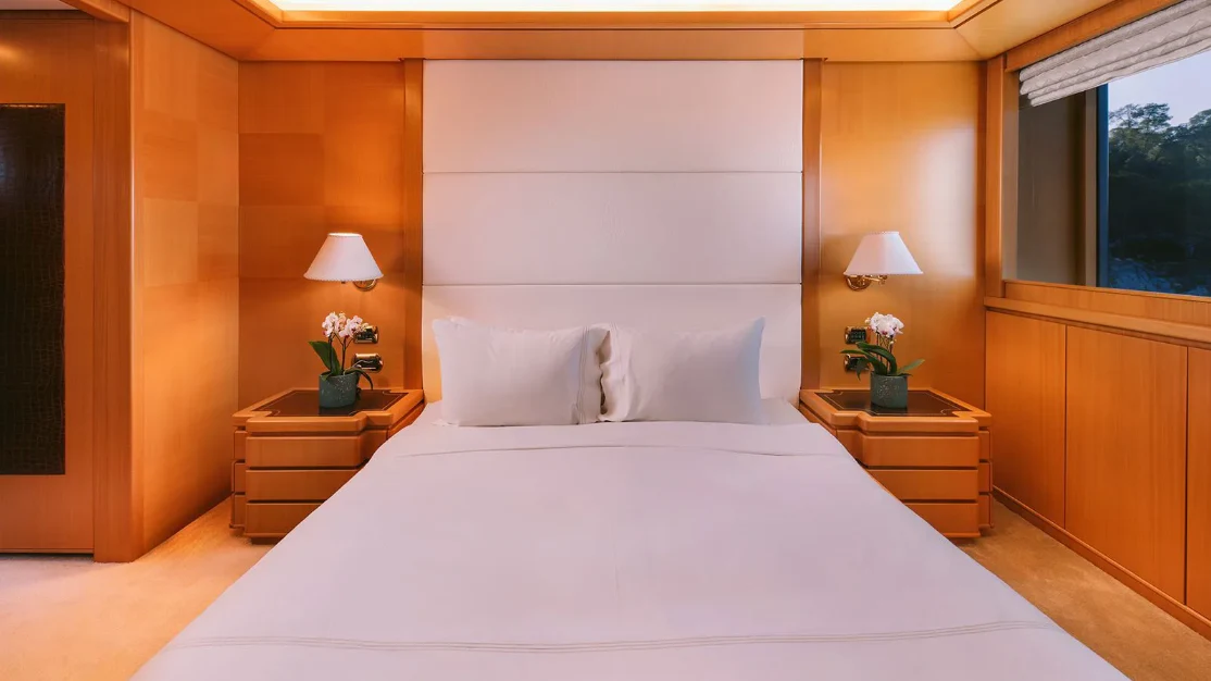 a bed with white sheets aboard OASIS Yacht for Sale