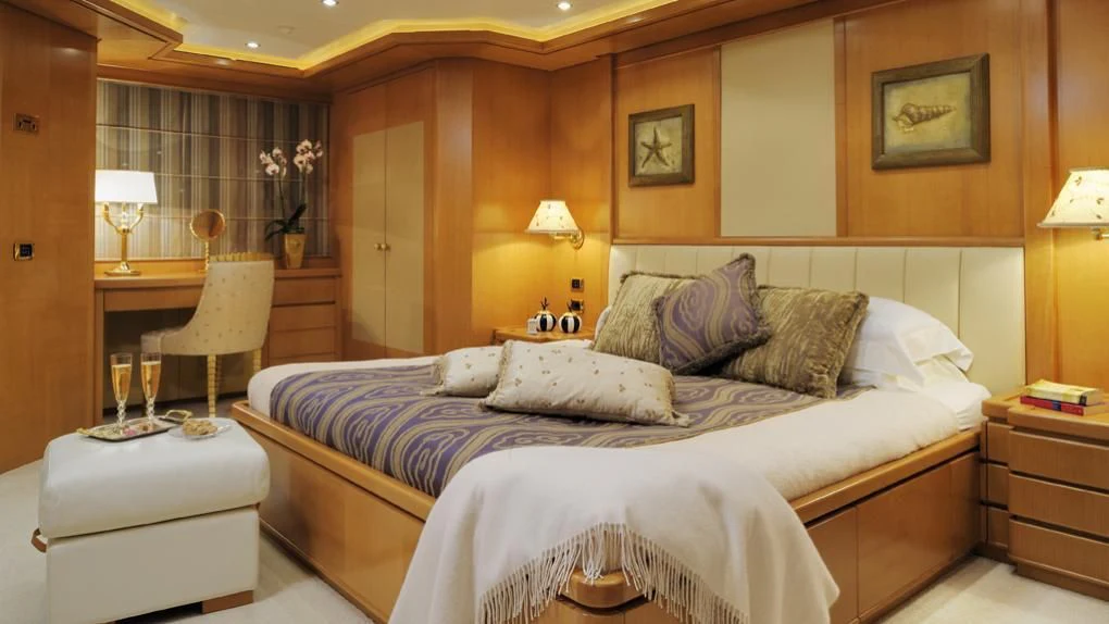 a bed with a white comforter aboard OASIS Yacht for Sale