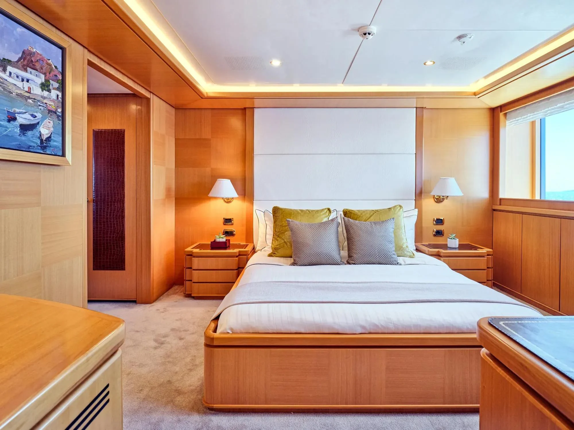 a bedroom with a bed and a desk aboard OASIS Yacht for Sale