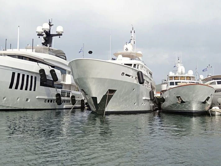 several white boats in a harbor aboard OASIS Yacht for Sale