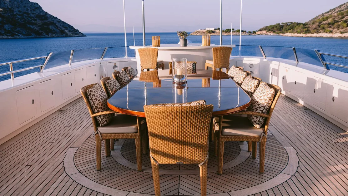 a table set on a deck overlooking the ocean aboard OASIS Yacht for Sale