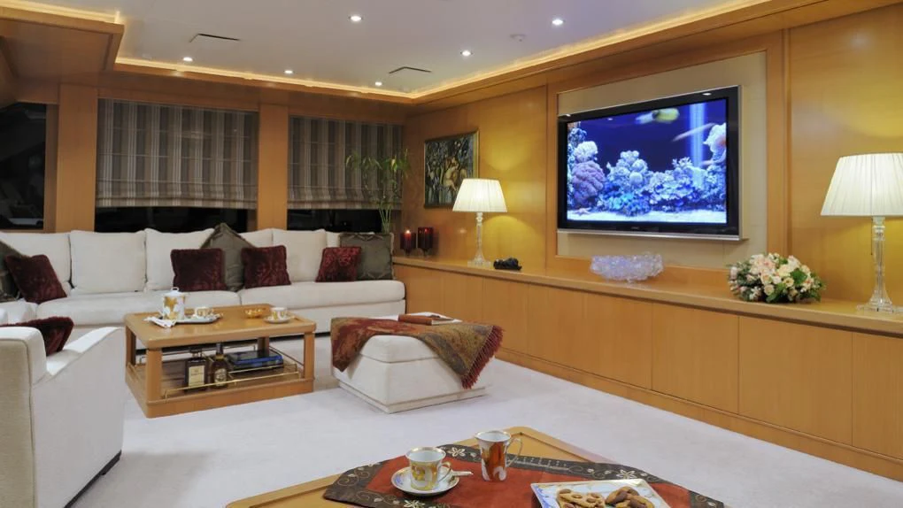 a living room with a large screen aboard OASIS Yacht for Sale