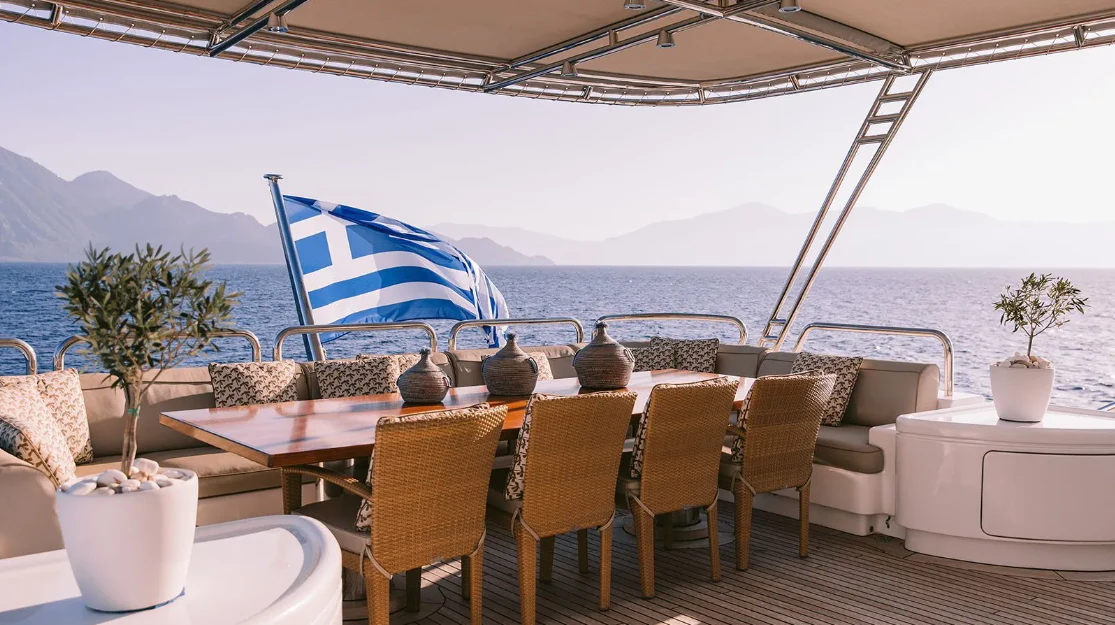 a table with chairs and umbrellas on it aboard OASIS Yacht for Sale