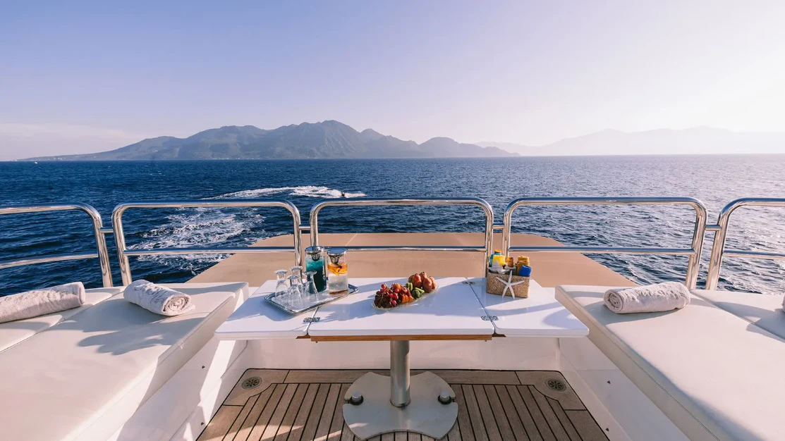 a boat with a table and chairs on the deck aboard OASIS Yacht for Sale