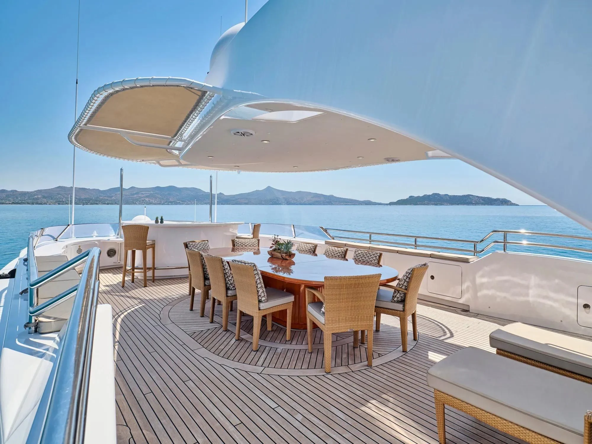 a deck with a table and chairs on it aboard OASIS Yacht for Sale