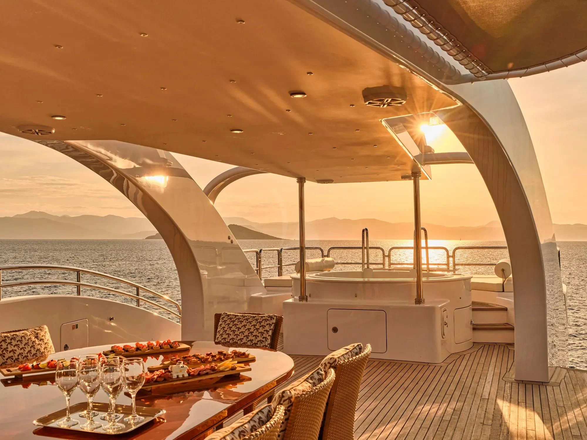 a table and chairs on a deck aboard OASIS Yacht for Sale