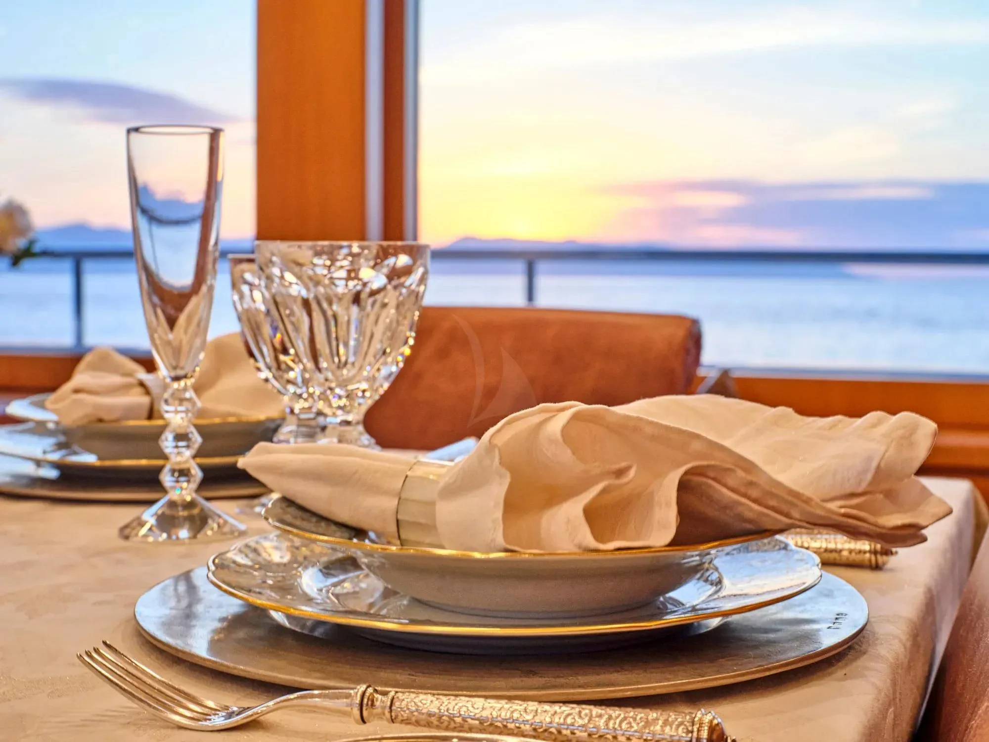 a plate of food and a glass of wine on a table aboard OASIS Yacht for Sale