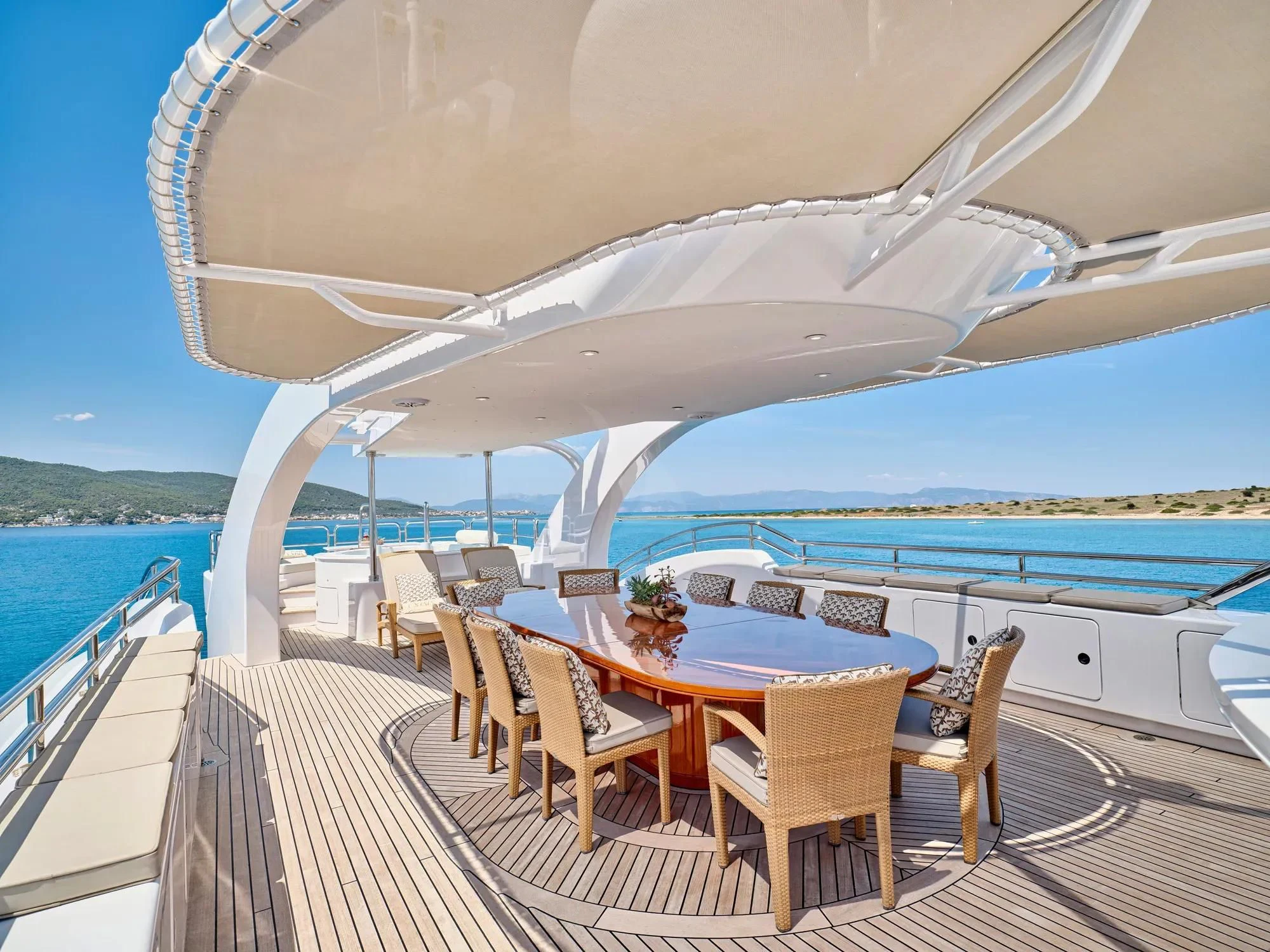 a deck with a table and chairs on it aboard OASIS Yacht for Sale