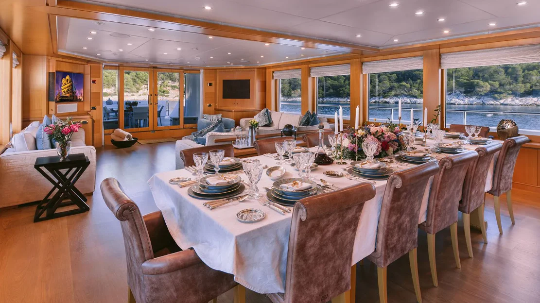 a dining room with a table set for a meal aboard OASIS Yacht for Sale