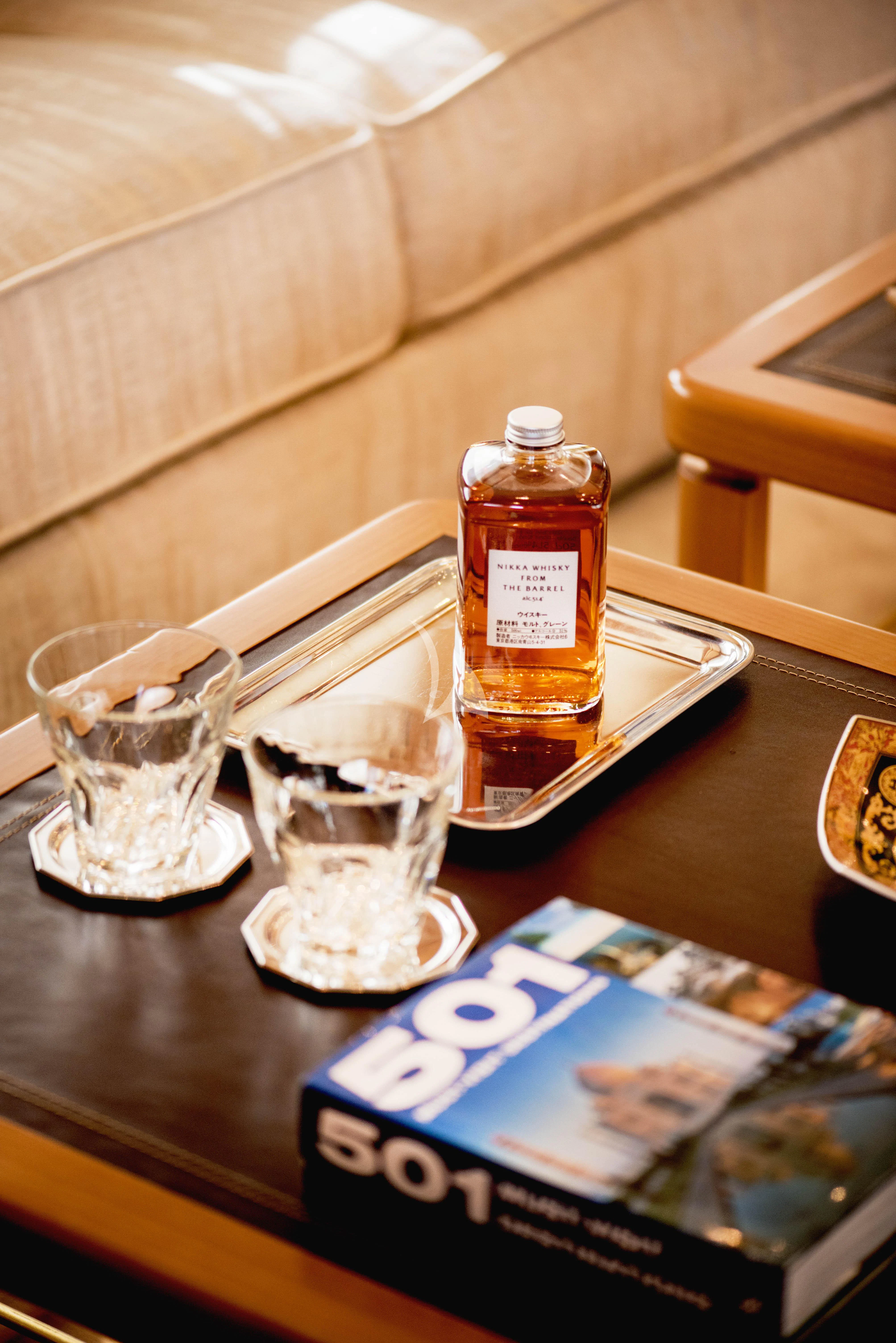 a bottle of alcohol on a table aboard OASIS Yacht for Sale