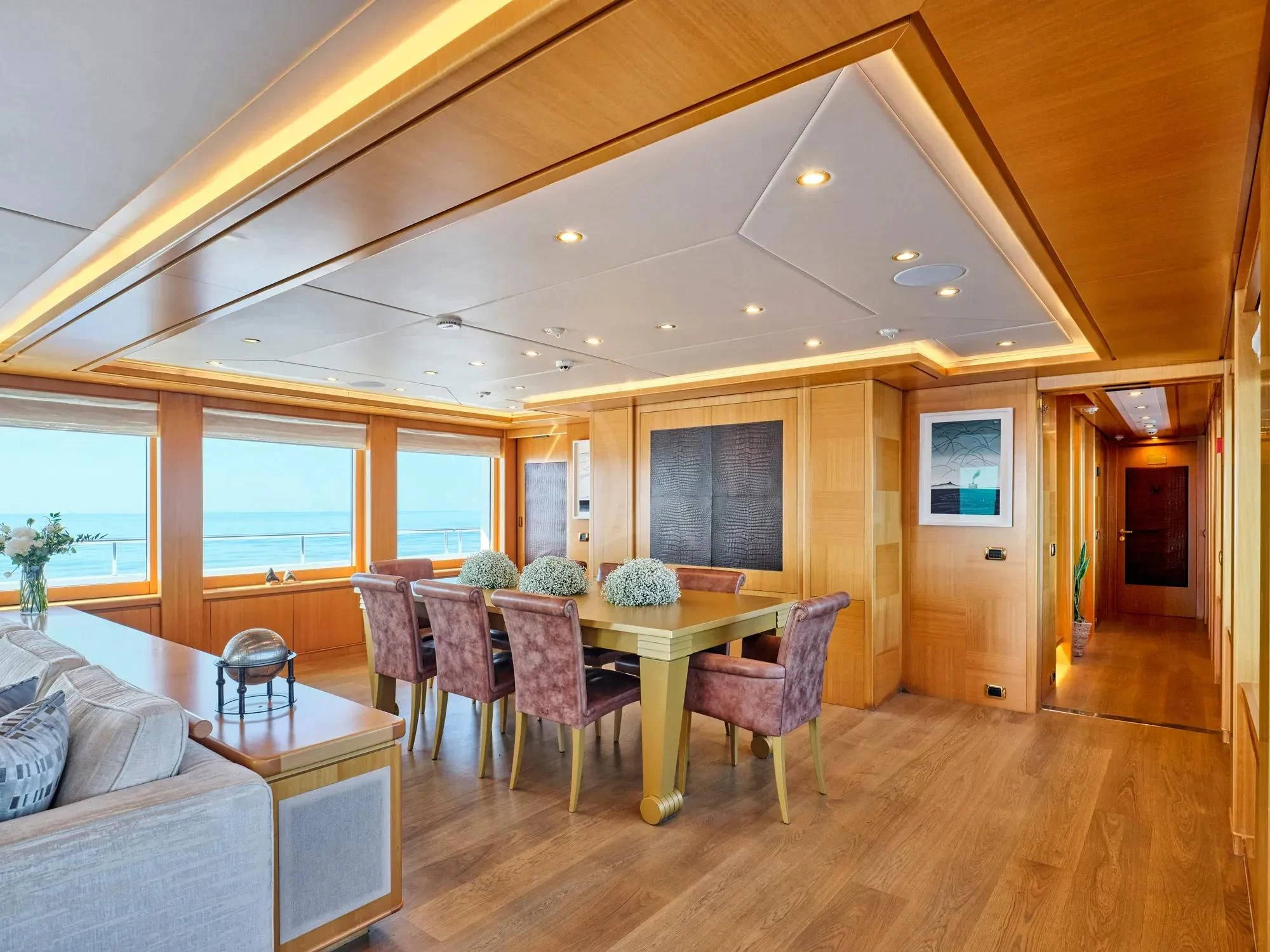 a living room with a table and chairs aboard OASIS Yacht for Sale