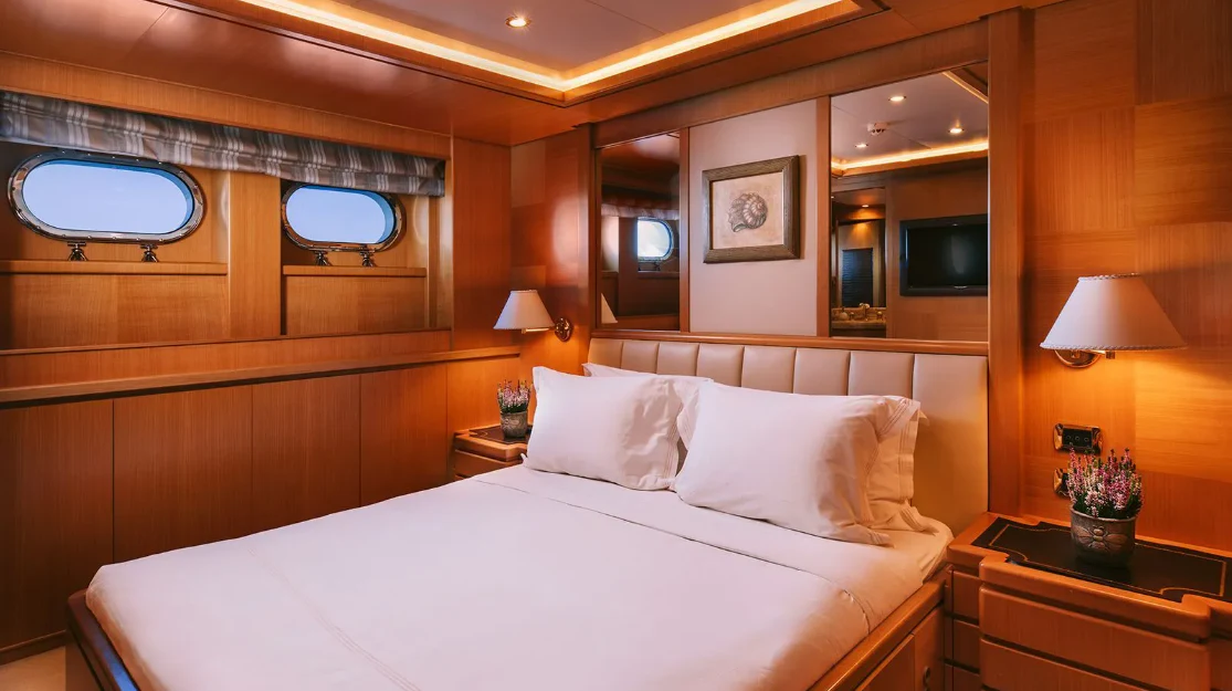 a bed with white sheets aboard OASIS Yacht for Sale