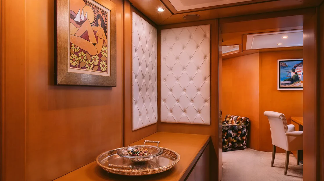 a room with a table and chairs aboard OASIS Yacht for Sale