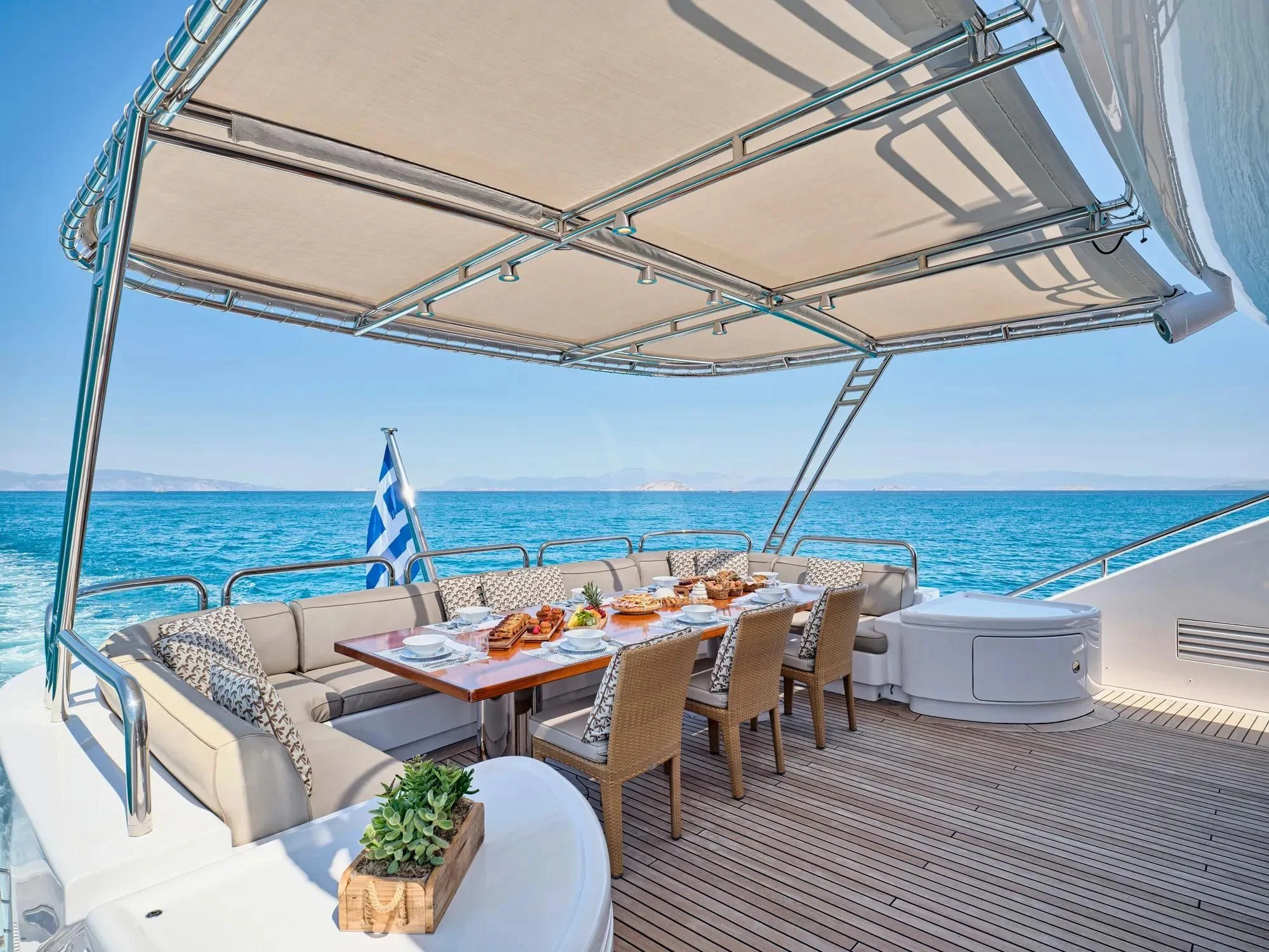 a patio with a table and chairs on it aboard OASIS Yacht for Sale