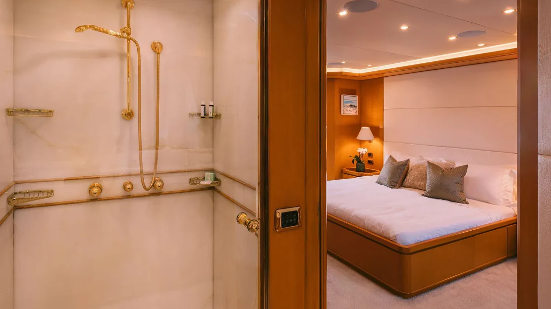 a hotel room with a bed and a mirror aboard OASIS Yacht for Sale
