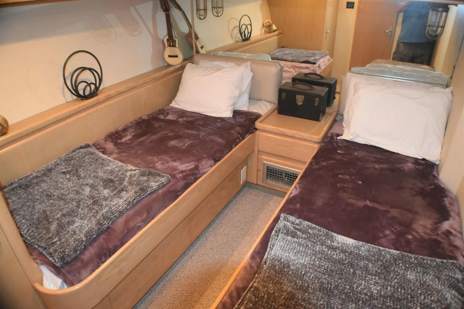 a bedroom with a bed and a dresser aboard JEWEL OF THE NILE Yacht for Sale