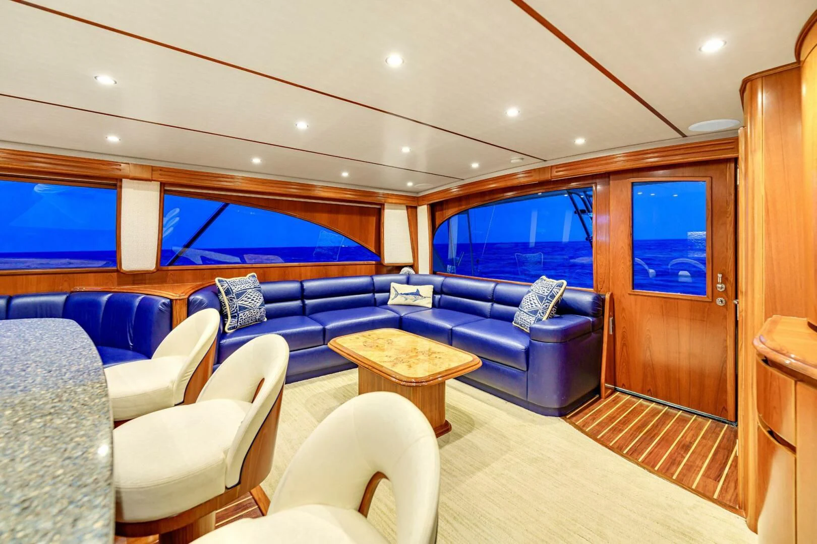 a living room with a blue couch and a wood door aboard LIFE IS GOOD Yacht for Sale