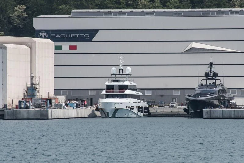 a large ship next to a smaller boat aboard RENATA Yacht for Sale